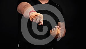 Adult man in a black uniform and muscular arms stands in a sports stance