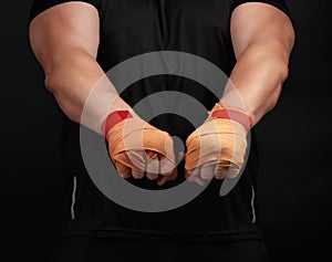 Adult man in a black uniform and muscular body is standing in a sports stance