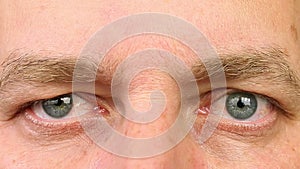 Adult man blinking his eyes. Extreme close-up view. Human eyes fast open up and shut down.