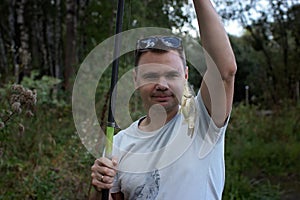 Adult man catching a fish on the lake