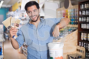 Adult man choosing brushes and varnishes