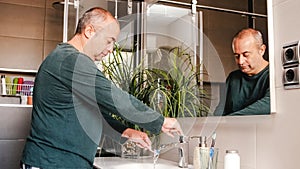 Adult man cleaning his teeth at home