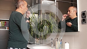 Adult man cleaning his teeth at home