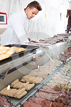 Adult man cook cutting meat in butcher market