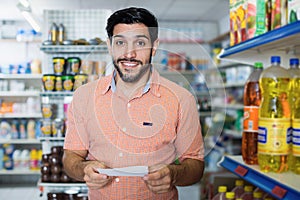 Adult man customer with note in supermarket
