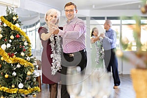 Adult man and elderly woman dancing tango
