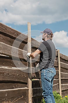 An adult man is engaged in carpentry work at a house construction site
