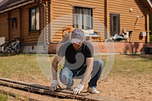 An adult man is engaged in carpentry work at a house construction site