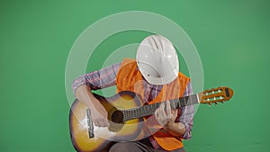 Adult man engineer playing the guitar