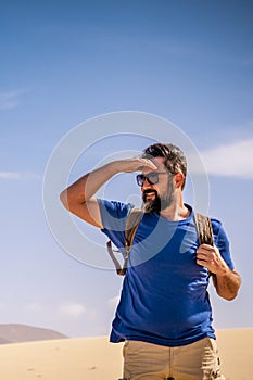 Adult man enjoy outdoor wild nature and adventure leisure activity alone walking inthe desert - mountains and blue sky in