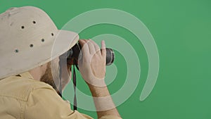 Adult man explorer watching through binoculars