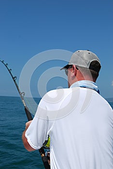 An adult man fishing in the ocean