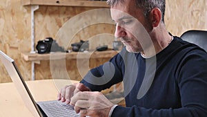 Adult Man Freelancer using a laptop to working online from home in internet