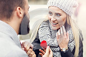 Adult man giving engagement ring to beautiful woman