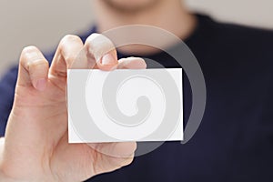 Adult man hand holding empty business card in front of camera