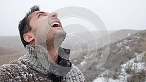 Adult man is happy to snowfall. Head is look up