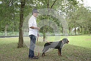Adult man and his pet dog in the park. Side view