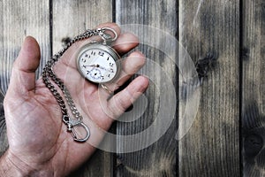 Adult man holding an antique pocket watch in his hand