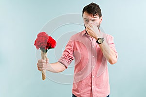 Adult man with an itchy nose and sneezing