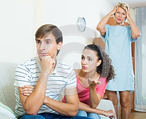 Adult man listening reproaches from girlfriend and her mother