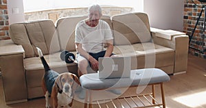 adult man and mature senior working his body with dumbbell - one man happy training indoors sitted on the sofa