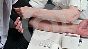 Adult man measurement of blood pressure by an electronic tonometer at home