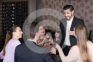 Adult man pronouncing toast in cozy restaurant