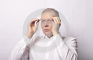 Adult man putting on glasses. Businessman wearing eyewear on white background