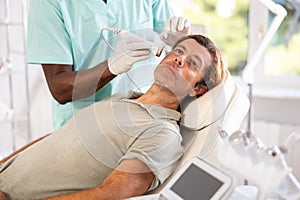 Adult man receiving high frequency ultrasonic facial procedure