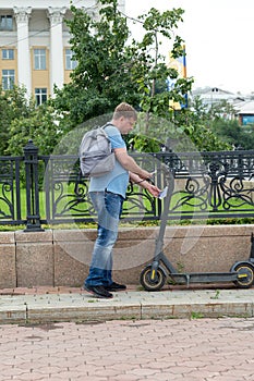 An adult man rents an electric scooter through