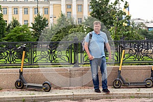 An adult man rents an electric scooter through