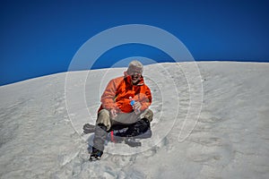 Adult man rests on a mountain with snow