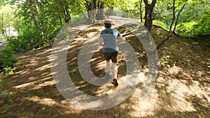 Adult man running jogging outdoors in a forest nature on a forest trail and enjoying it and looking happy