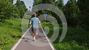 Adult man running jogging outdoors in a forest nature on a forest trail and enjoying it and looking happy