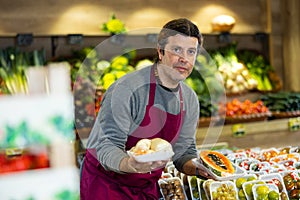 Adult man selling papaya and roots in shop