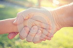 an adult man shakes hands with a child. The concept of salvation