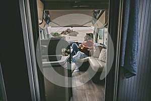 Adult man sitting inside van camper motorhome. Tourist of alternaive people lifestyle. Travel and enjoying freedom. Holiday