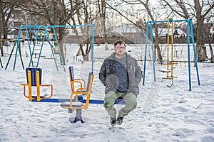 Adult man sitting on a swing