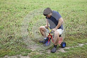 Adult man on a small tricycle