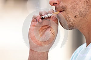 Adult man smoking cigarette outside