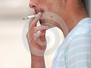 Adult man smoking cigarette outside