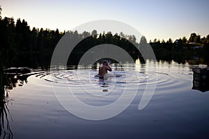 Adult man splash water in forest lake