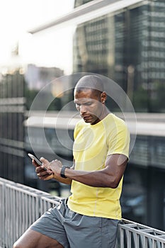 Adult man synchronizing mobile phone and smartwatch to do sports in the city