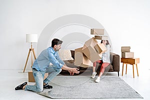 Adult man trying to catch cardboard boxes falling on floor