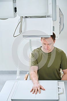 Adult man undergoing upper extremity x-ray examination photo