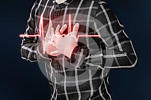 An adult man uses his hand to hold his chest. After having a heart attack symptom.