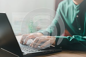 Adult man using laptop computer with virtual screen contact questionnaire with checkbox.