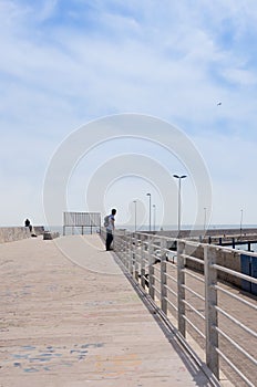Adult man visits the city of Bari, view from the pier, Italy