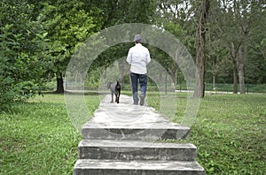 Adult man walking his pet dog in the park