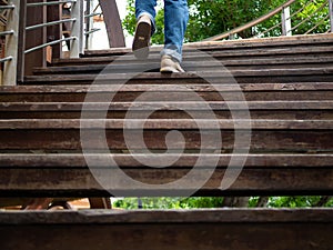 Adult man walking up the wooden stairs. Moving forward Concept.